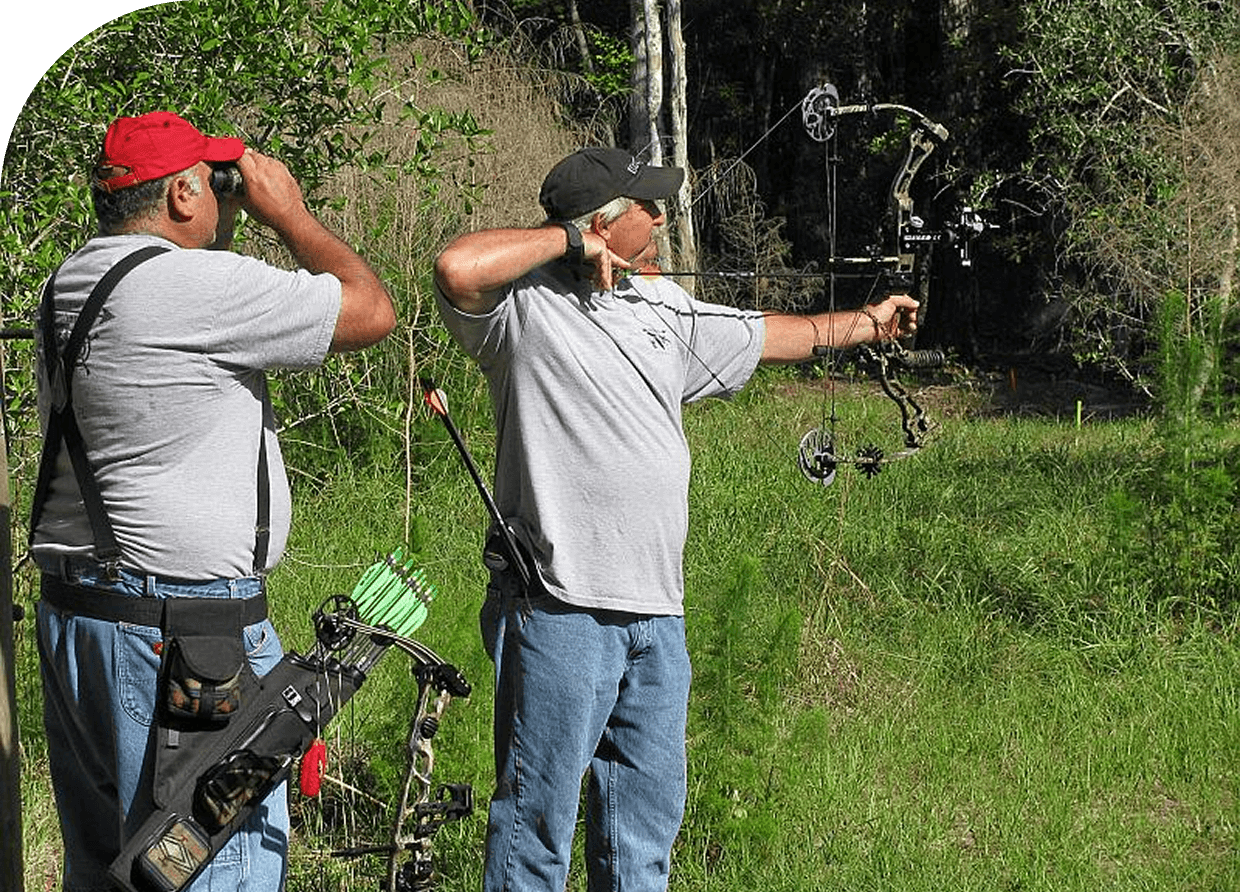 Two men engaged in archery outdoors