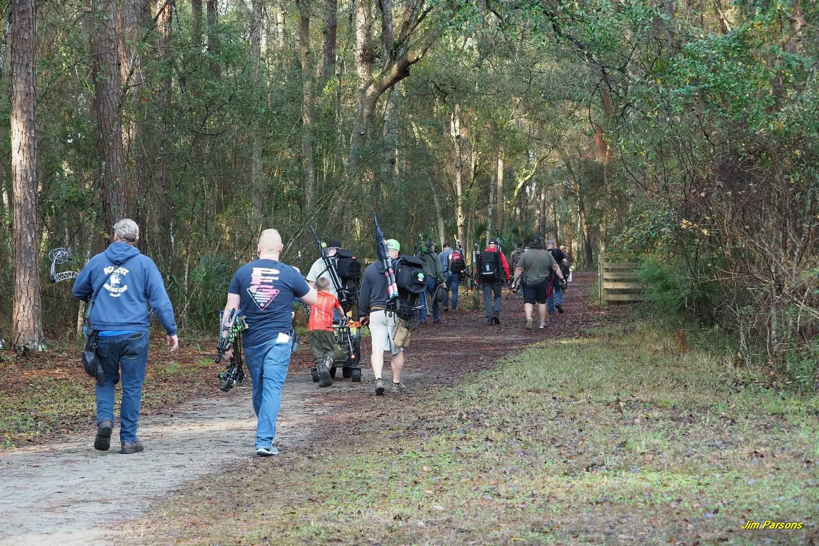 Group of people hiking on a forest trail during daytime.