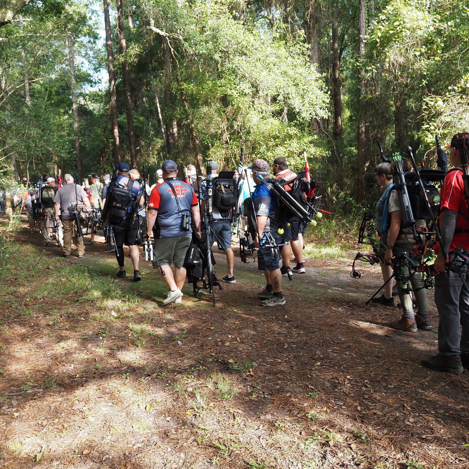 A group of people hiking through a forest trail.